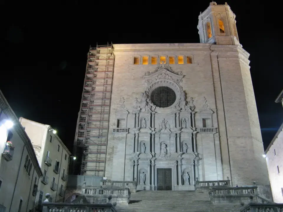 Facciata monumentale di una chiesa in pietra illuminata di notte.
