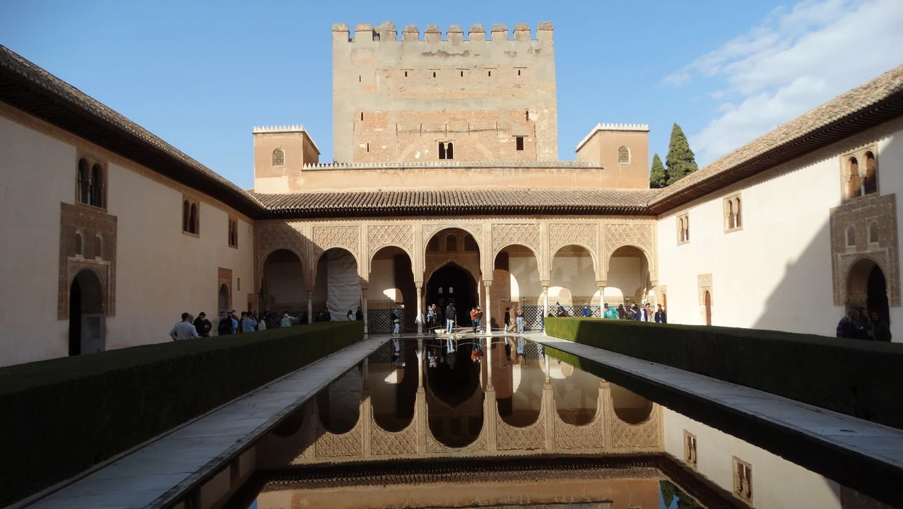 Vista prospettica di un complesso palatino andaluso con cortili e archi in pietra.