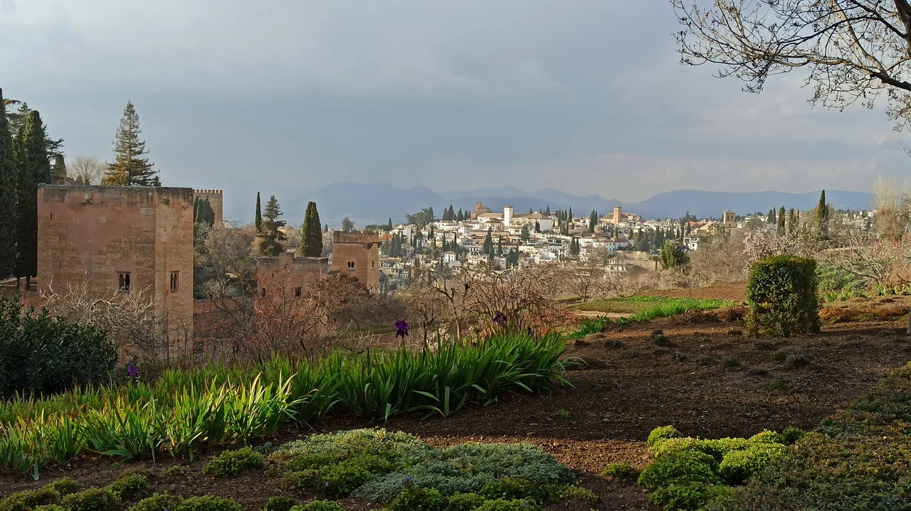 Paesaggio rurale e architetture in primo piano con una città sottostante.