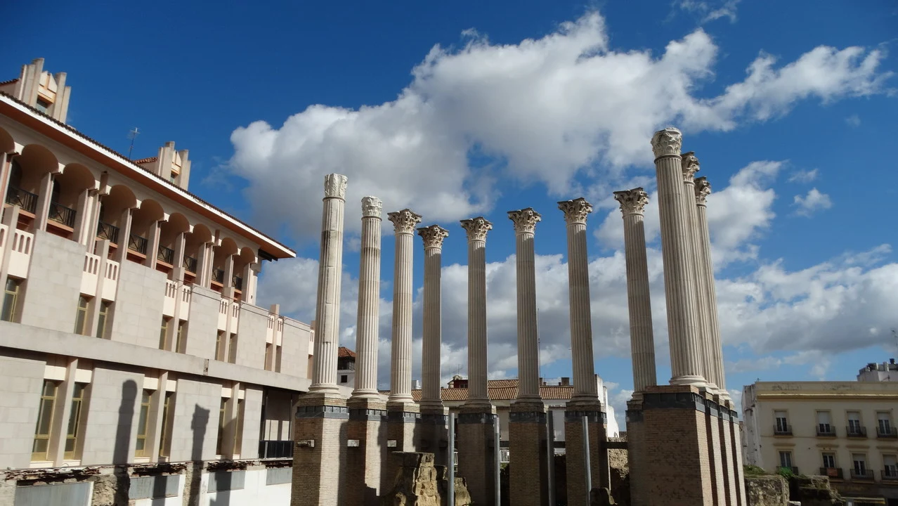 Colonne romane antiche si stagliano contro il cielo sopra un edificio in pietra.