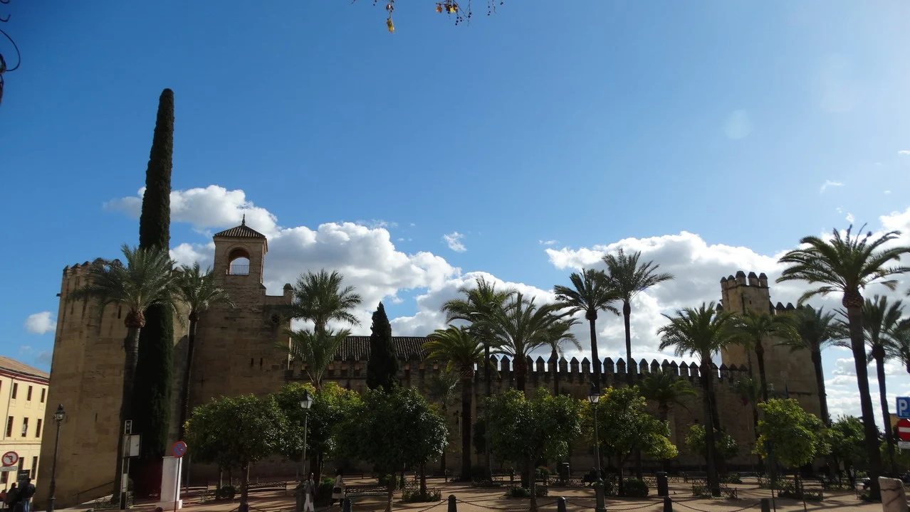 Vista panoramica del castello di Cordoba con palme e vegetazione.