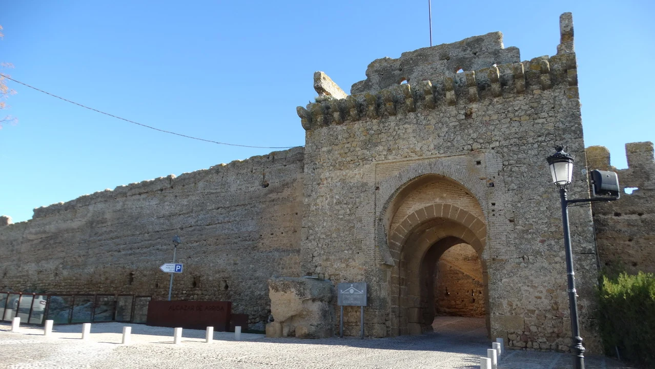 Mura in pietra della fortezza di Carmona con arco d'ingresso.