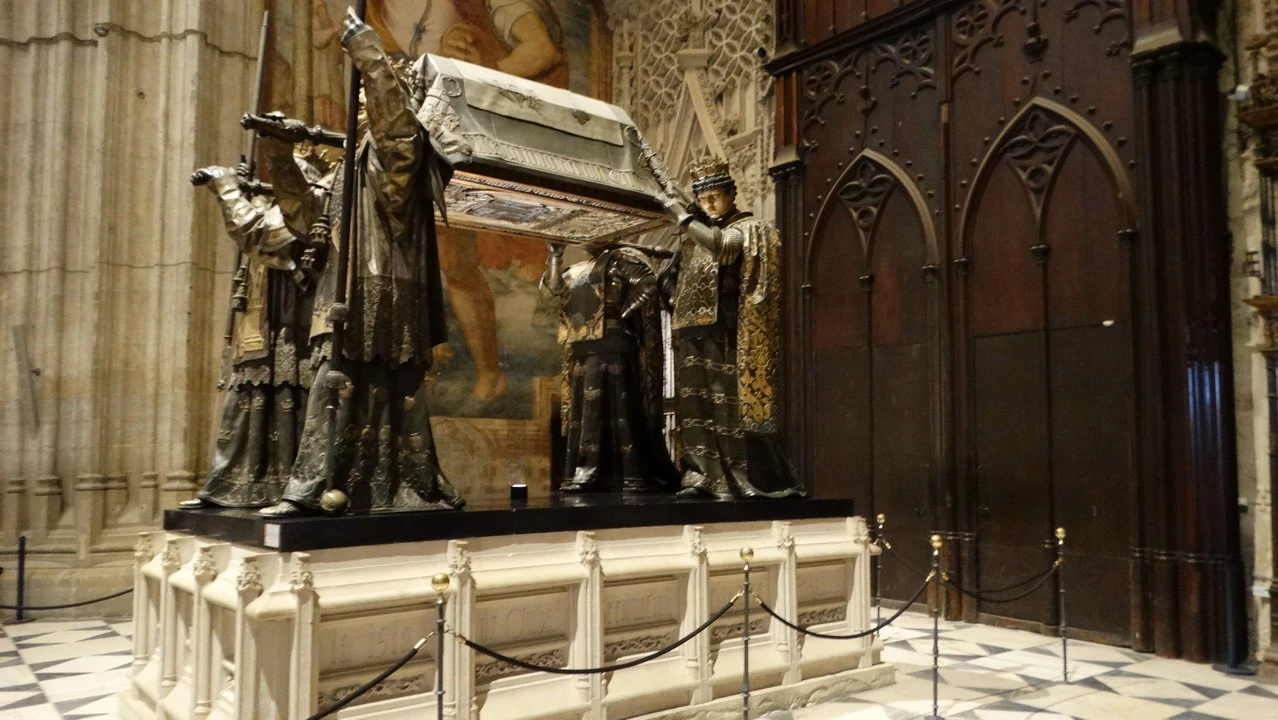 Interno ornato di una sala storica con sculture e pannellature in legno scuro.