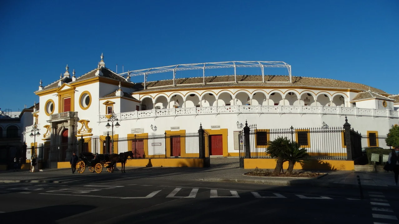 Facciata della Plaza de Toros di Siviglia con una recinzione in primo piano.