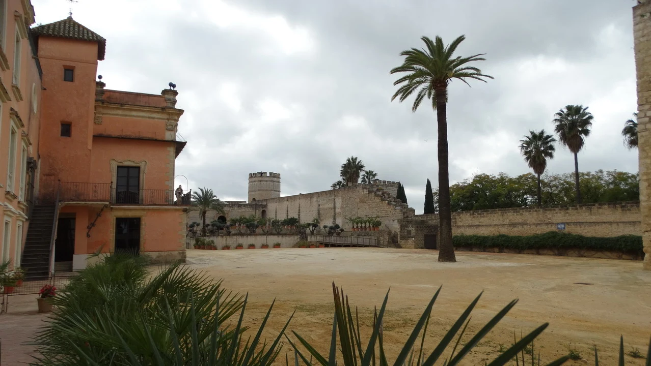 Vista di un palazzo con mura antiche in un contesto mediterraneo.