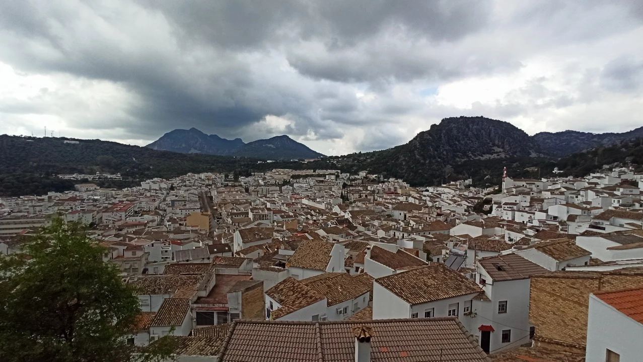 Vista panoramica del paesaggio urbano e collinare dell'Andalusia e dell'Algarve sotto un cielo nuvoloso.