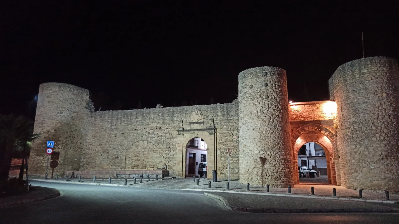 Mura in pietra di una fortezza illuminata di notte.