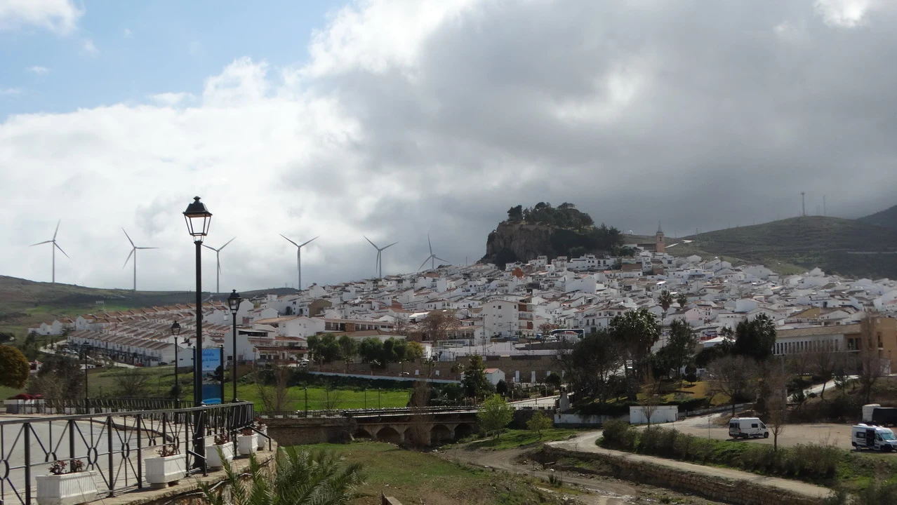 Una vista panoramica di un paesaggio urbano collinare sotto un cielo nuvoloso in Andalusia o Algarve.