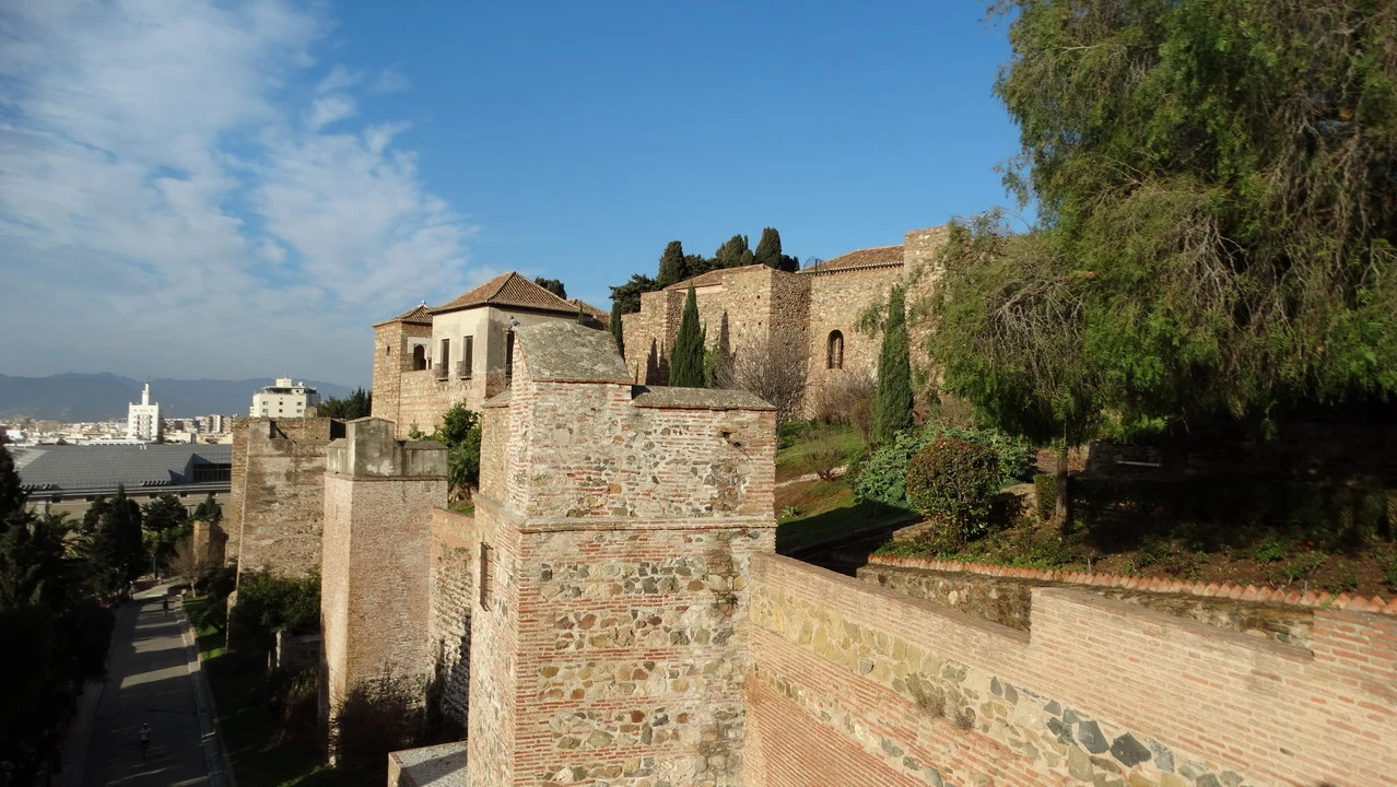 Vista panoramica di un castello in pietra con vegetazione circostante.