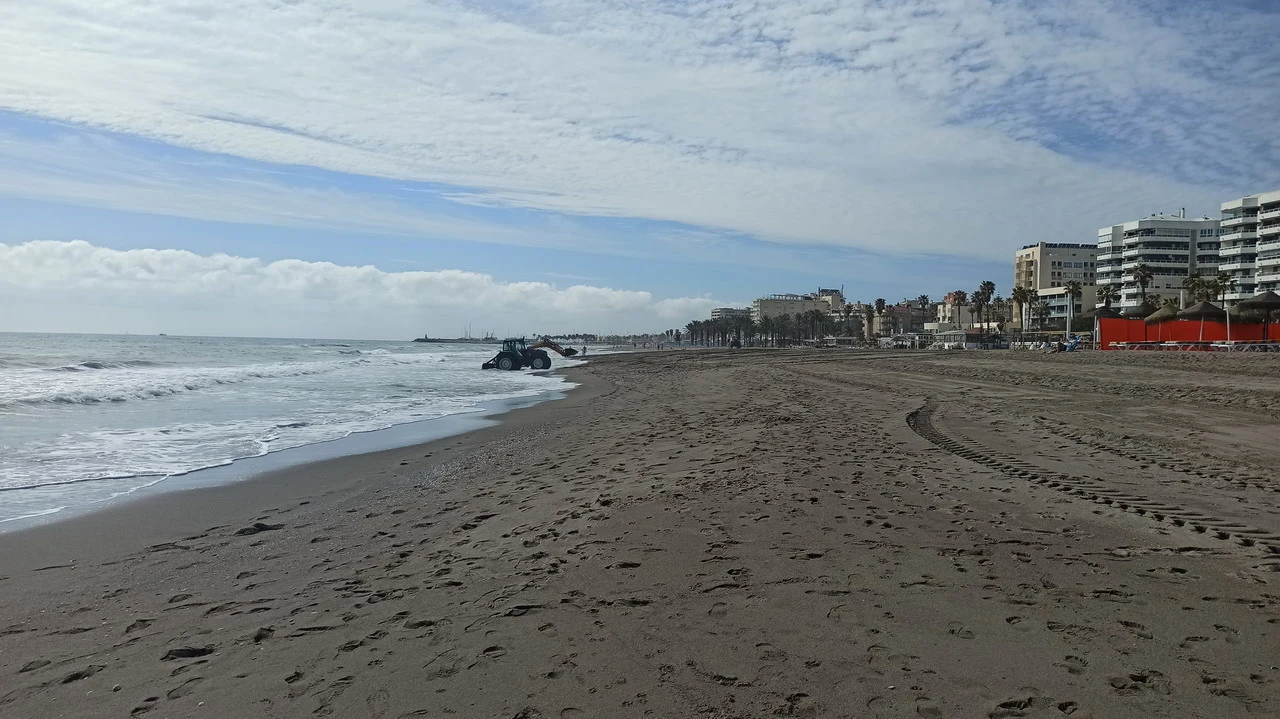Spiaggia sabbiosa con edifici residenziali lungo la costa.