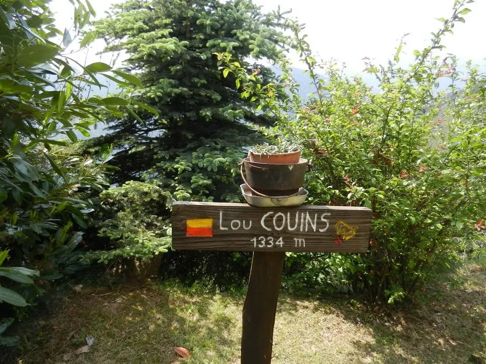 Segnale stradale che indica la località Lou Couins e l'altitudine di 1334 metri.