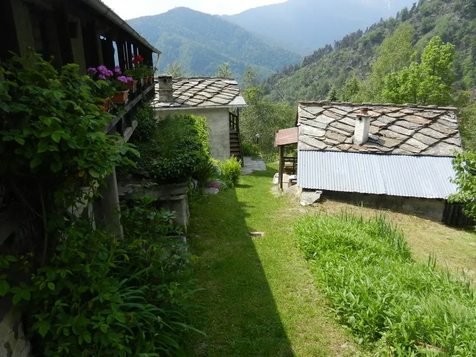 Vista panoramica di case rurali incastonate tra le montagne verdi.