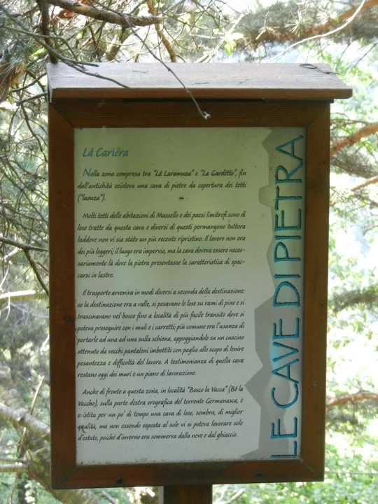 Cartello in pietra con iscrizioni sul sentiero.