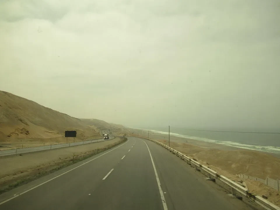 Una strada costiera attraversa un paesaggio arido in Perù o Bolivia.