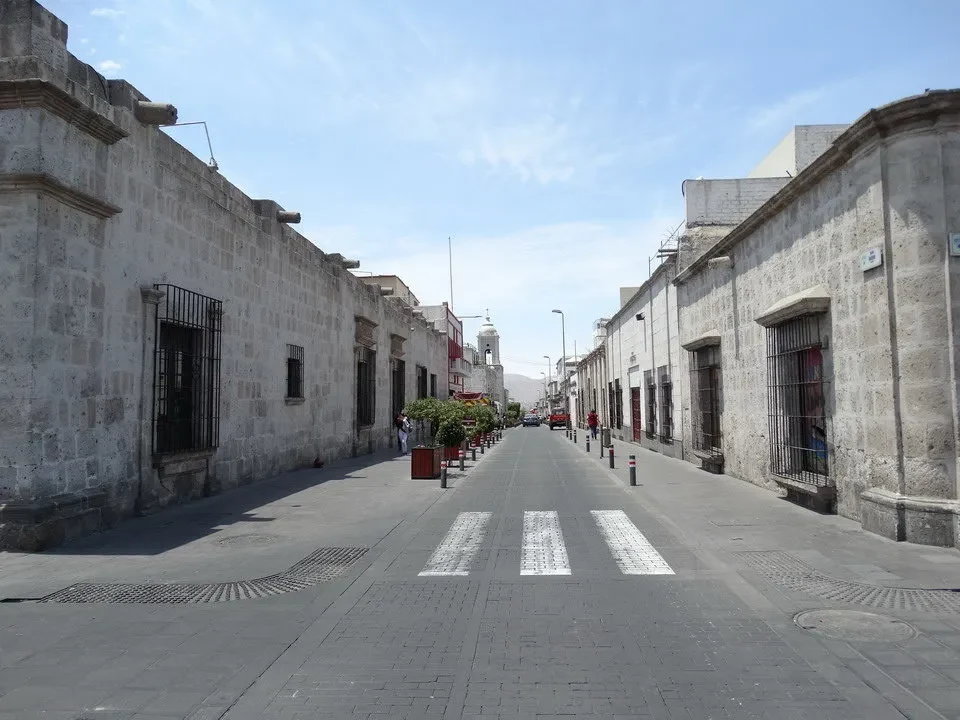 Una strada ampia e storica in pietra si estende tra edifici coloniali in Arequipa, Perù.