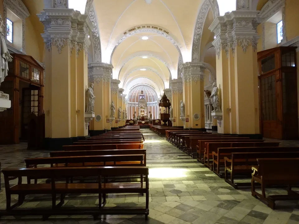 Interno della cattedrale di Arequipa con file di panche in legno lungo l'arco.