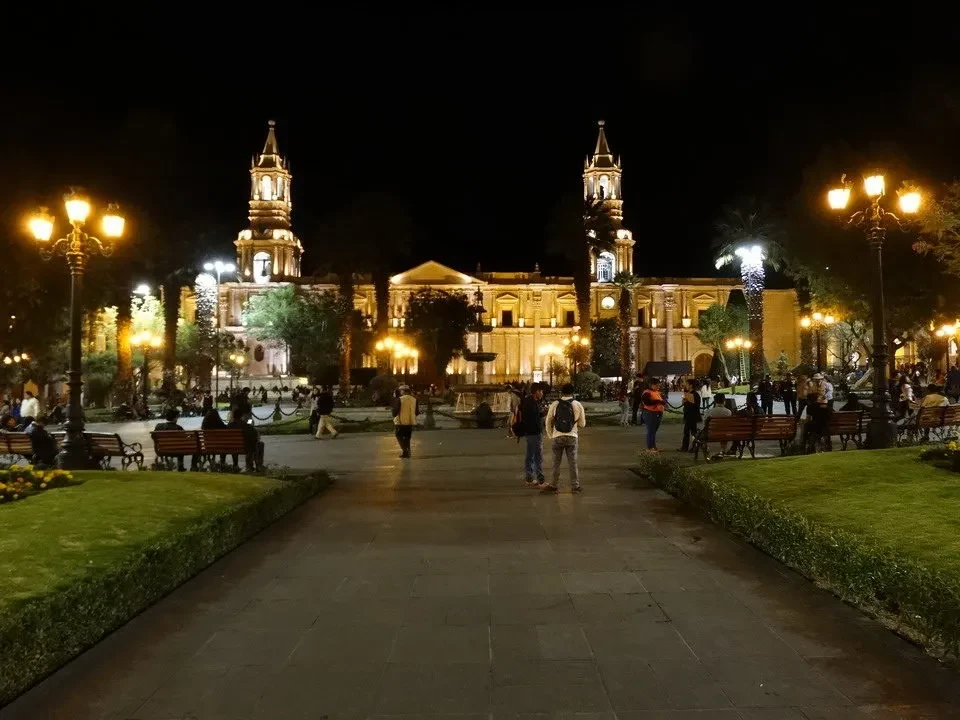 Veduta notturna della Plaza de Armas con edifici storici illuminati.