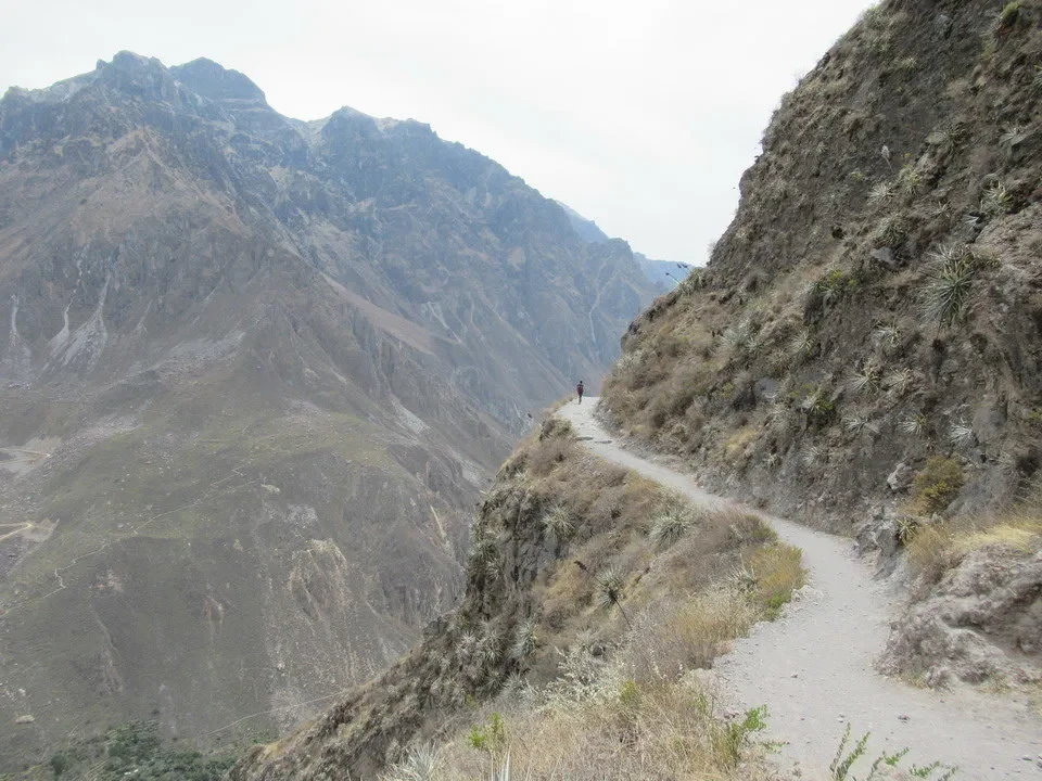 Sentiero sterrato attraversa un paesaggio montano aspro tra le montagne del Perù e della Bolivia.
