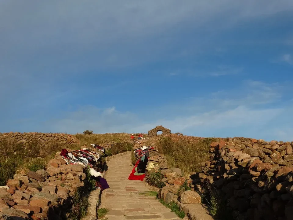 Un sentiero di pietra conduce attraverso un paesaggio arido in Perù e Bolivia.