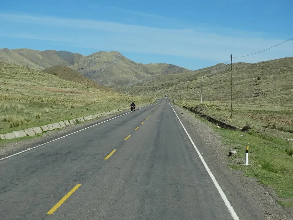 Una strada asfaltata attraversa un paesaggio montano in Perù e Bolivia.