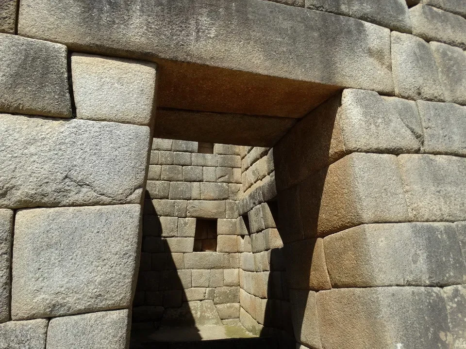 Vista ravvicinata della struttura in pietra di Machu Picchu con ombre marcate.
