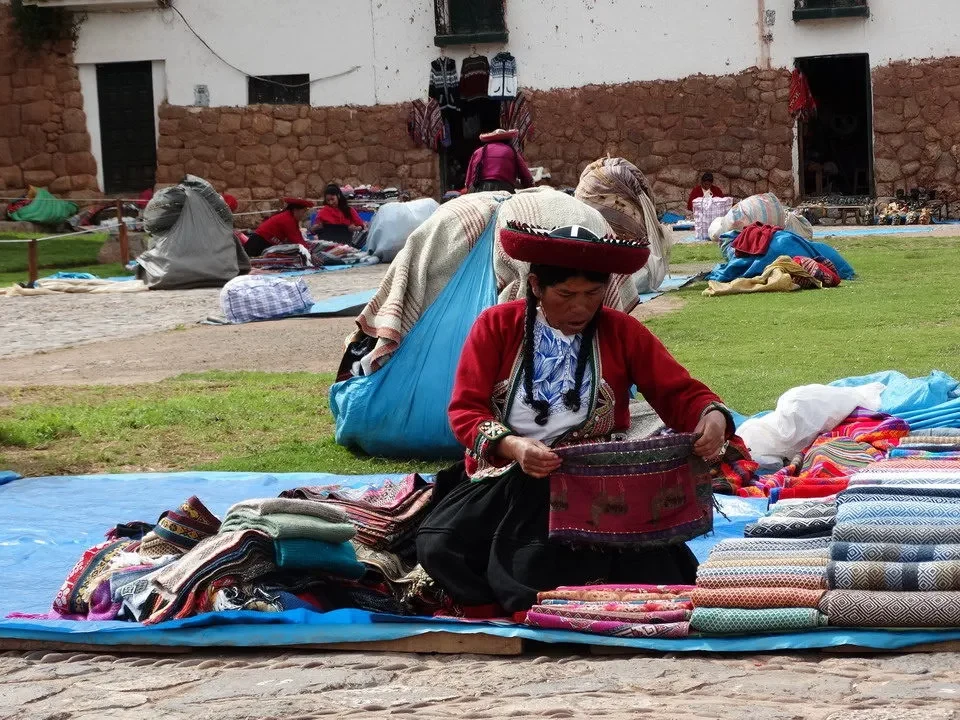 Artigiani in un mercato all'aperto mostrano tessuti colorati in Perù o Bolivia.