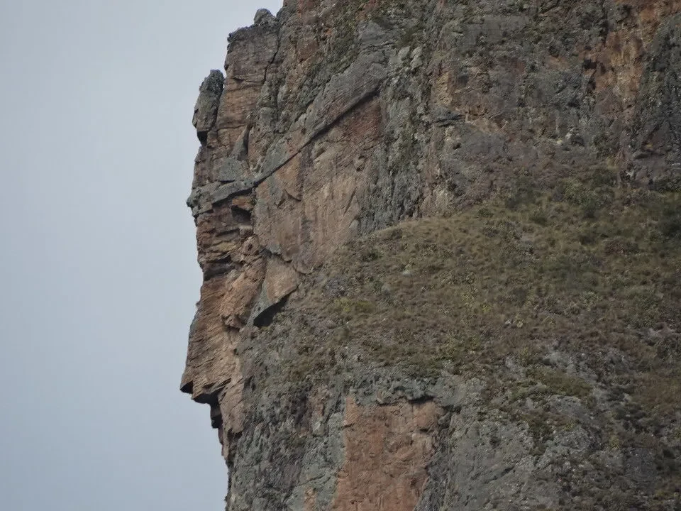 Parete rocciosa imponente con vegetazione secca in Perù o Bolivia.