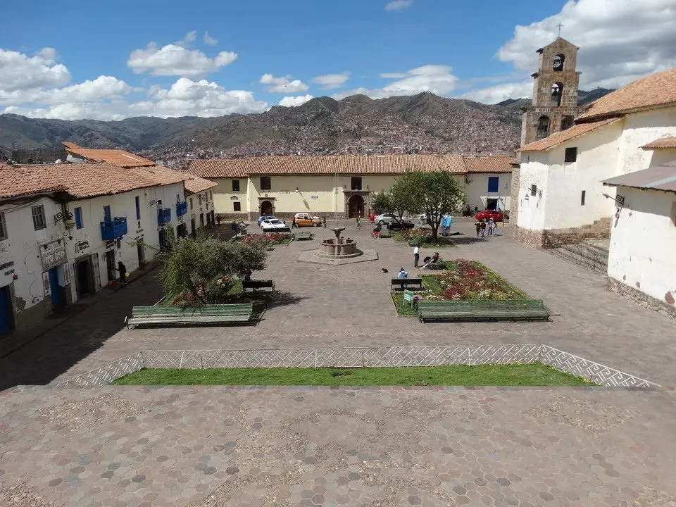 Piazza San Blas a Cusco, Perù, con edifici storici e montagne sullo sfondo.