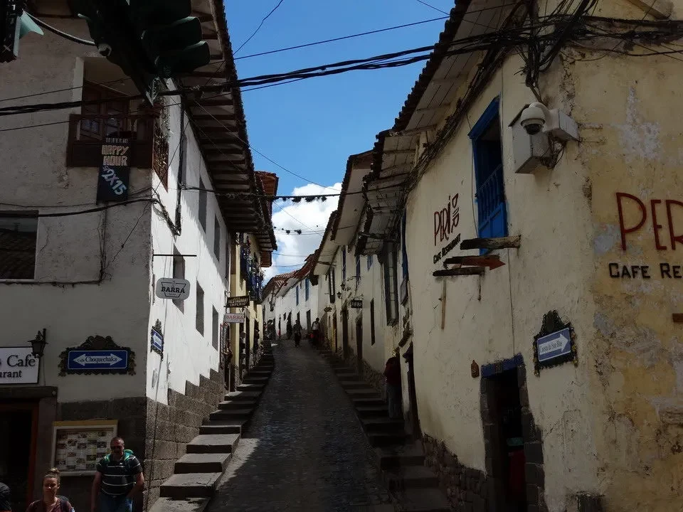 Una via stretta e antica con edifici colorati fiancheggia un vicolo in Perù o Bolivia.
