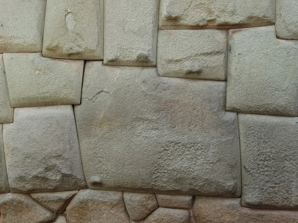 Muro di pietra antico con blocchi squadrati in un'architettura andina.