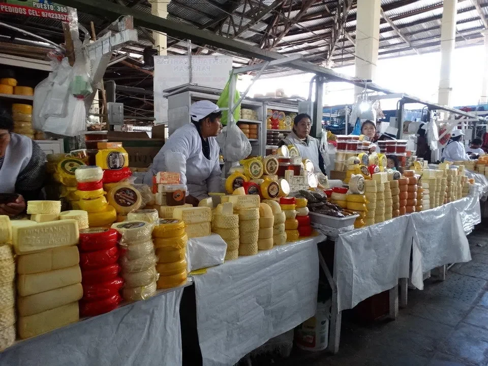 Mercato di Cusco con bancarelle di prodotti alimentari in primo piano.