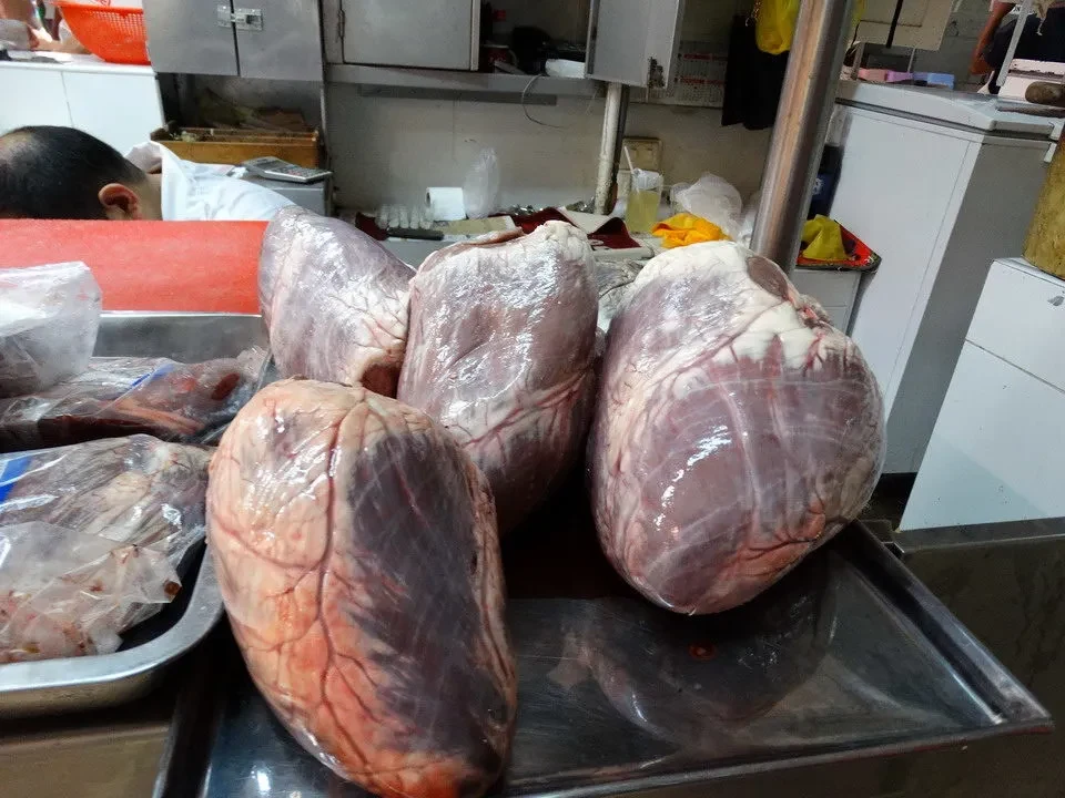 Carne fresca esparsa sobre una mesa en un mercado peruano.