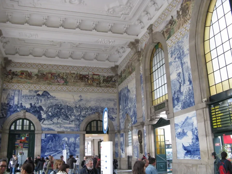 Interno di una stazione ferroviaria storica a Porto con decorazioni murali blu e bianche. Interno di una stazione ferroviaria storica a Porto con decorazioni murali blu e bianche.