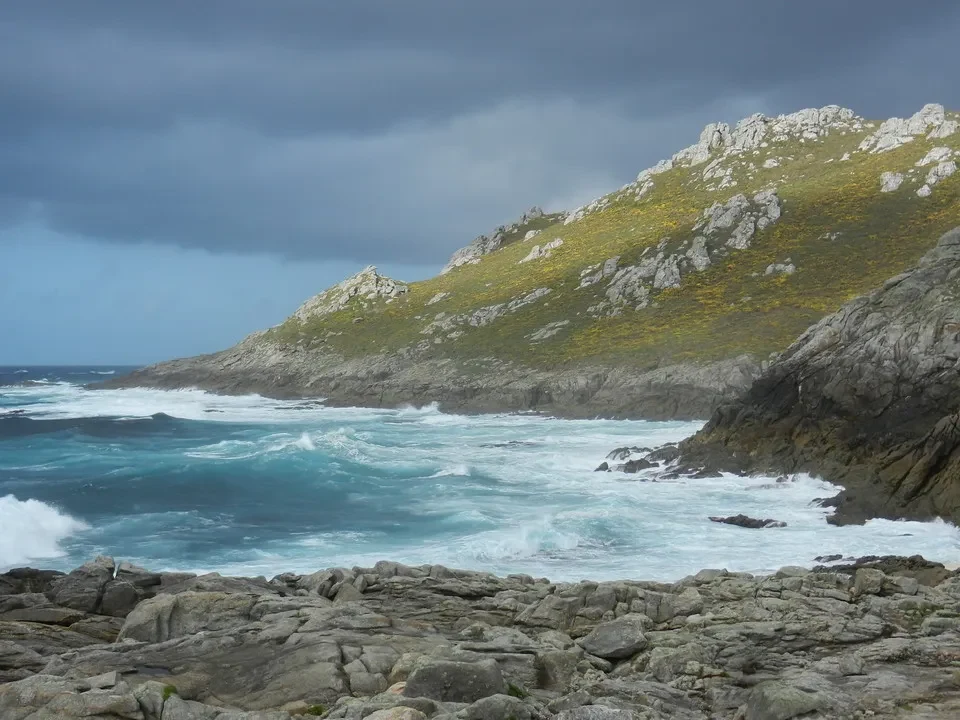 Paesaggio costiero roccioso con onde che si infrangono contro la terra verdeggiante. Paesaggio costiero roccioso con onde che si infrangono contro la terra verdeggiante.