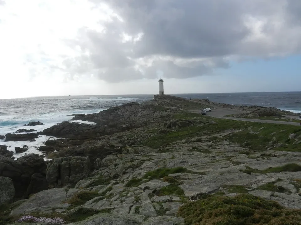 Faro di Capo Rotundo visibile sopra il paesaggio costiero portoghese.