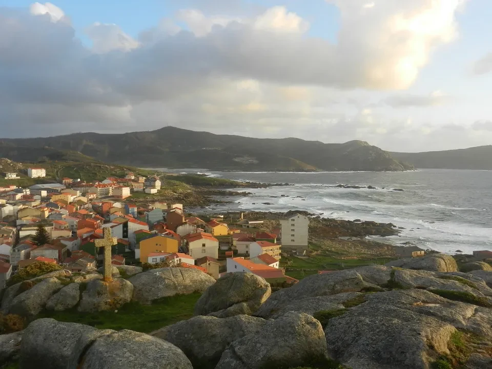 Una vista panoramica di un villaggio costiero in Portogallo con montagne sullo sfondo.