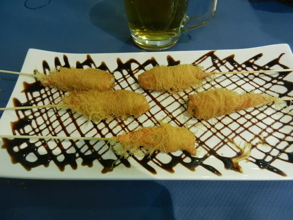Pesce fritto con salsa al cioccolato su un piatto di legno.