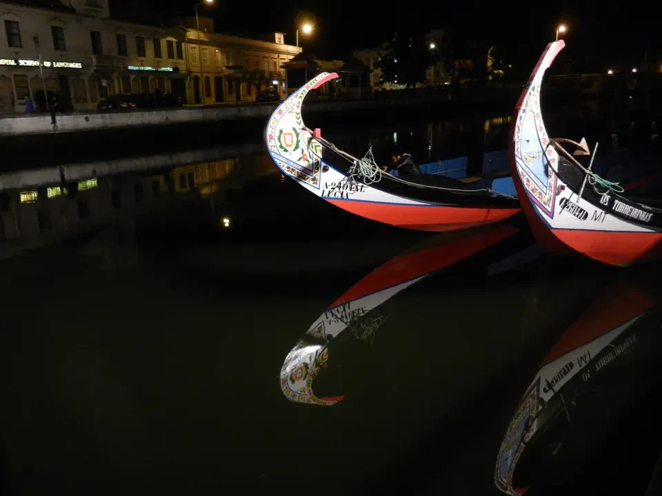 Barche tradizionali navigano sul fiume al tramonto.