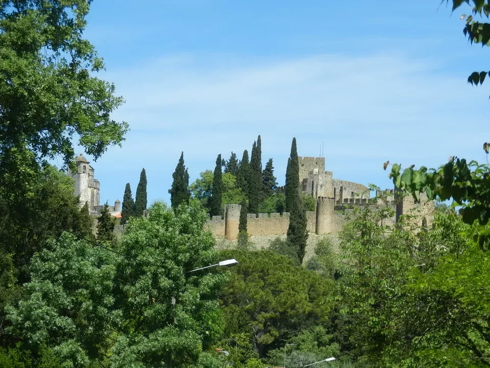 Vista panoramica del Convento de Cristo in Portogallo con vegetazione lussureggiante.