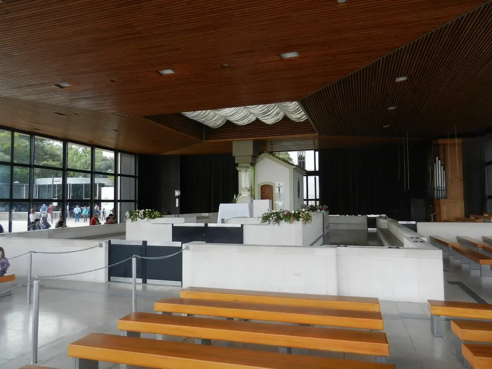 Interno moderno di una chiesa in Portogallo con panche di legno e pareti chiare.