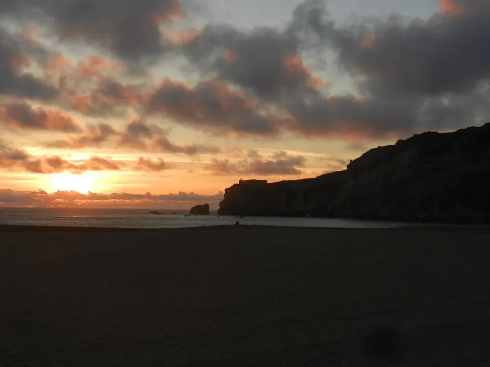 Tramonto spettacolare sul mare con scogliere costiere.