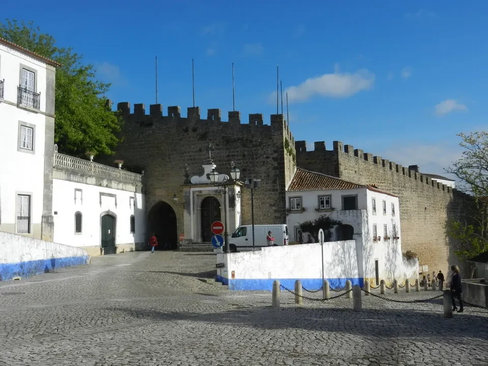 Vista della cinta muraria di Obidos in Portogallo con edifici bianchi e pietra.