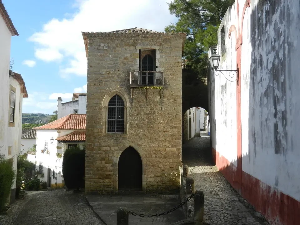 Vicoli storici pavimentati con ciottoli e antiche mura in pietra in Portogallo.