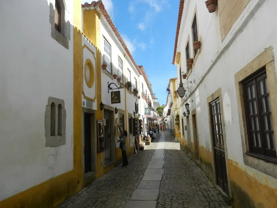 Una strada acciottolata fiancheggiata da edifici colorati si snoda attraverso una città portoghese.