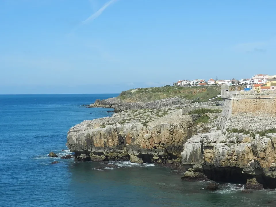 Una vista panoramica della costa rocciosa di Peniche con edifici bianchi.