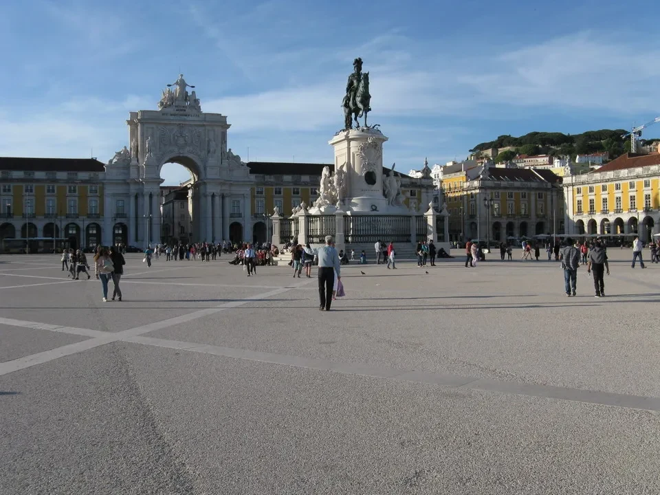 Una veduta ampia della Praça do Comércio a Lisbona con la fontana e la statua.