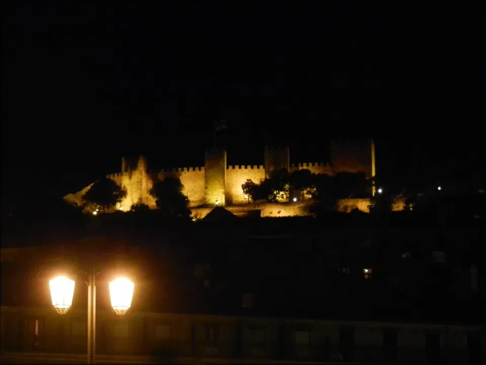 Il castello di Lisbona è illuminato di notte.
