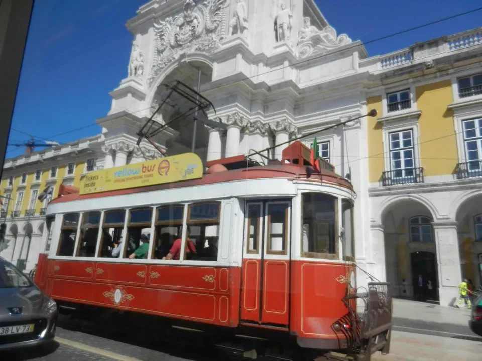 Un tram rosso attraversa una strada storica a Lisbona, Portogallo.