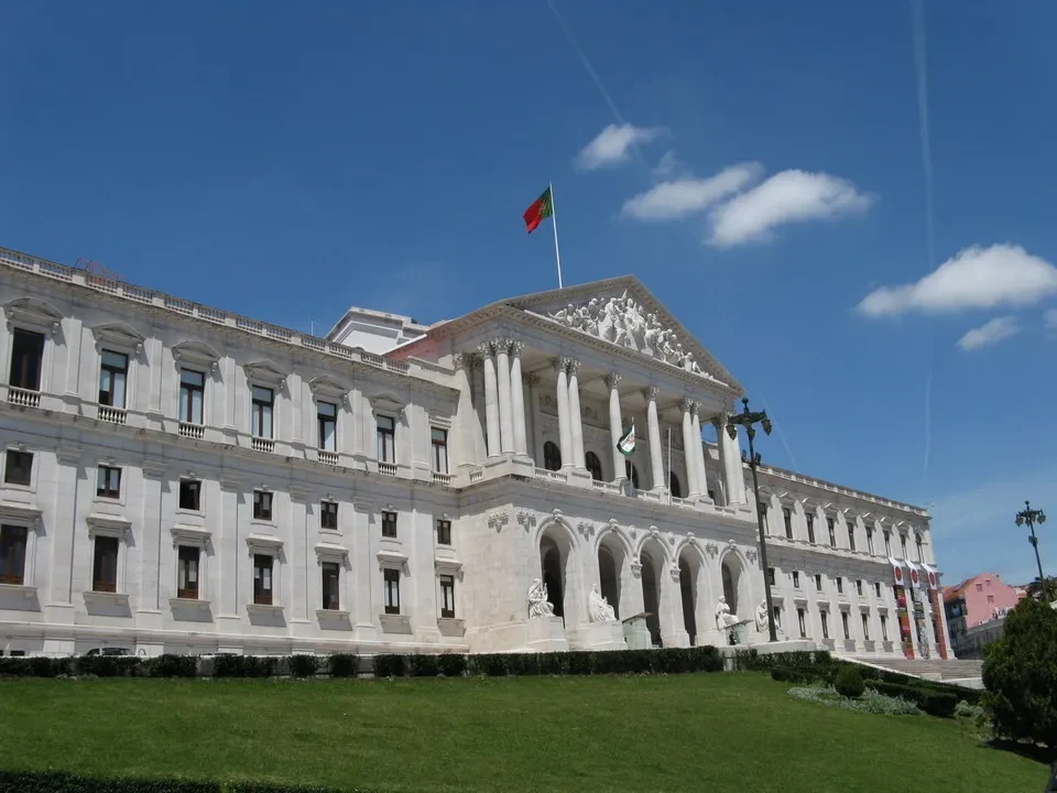 Facciata del Palazzo d'Assemblea della Repubblica a Lisbona con la bandiera sventolante.