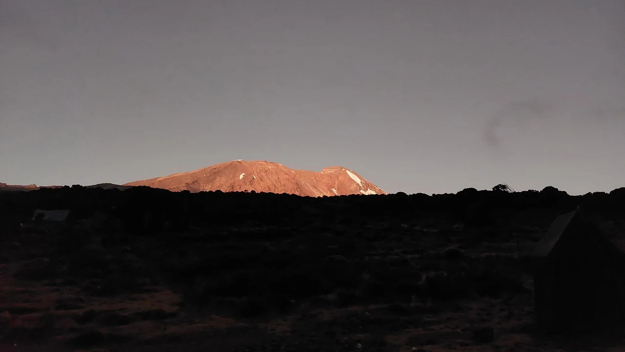 Una montagna arida si staglia contro il cielo in una savana africana.